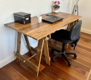 Reclaimed timber desk with laptop, mobile phone and pens on surface and reclaimed hardwood timber trestle legs