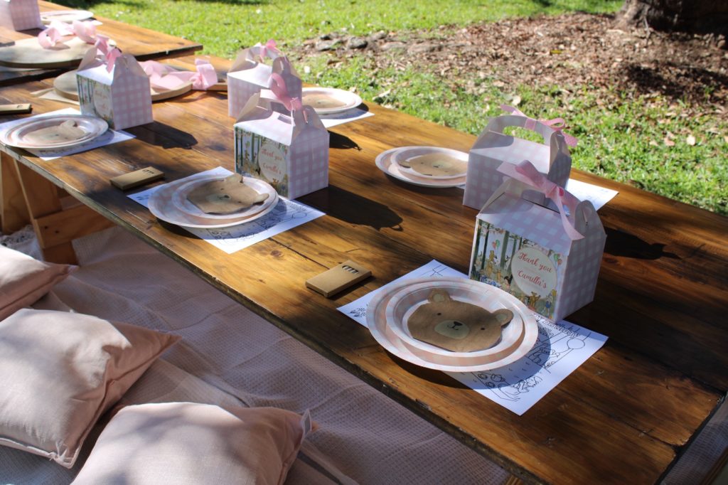 Low Boho Trestle Tables for a children's party with plates and gift boxes on top